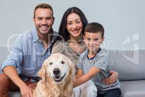 Happy parents with son and pet in living room