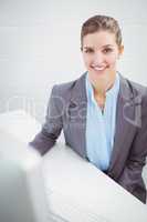 Happy businesswoman sitting at desk in office