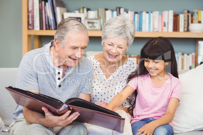Grandparents showing album to granddaughter