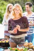 Beautiful woman having juice at outdoors barbecue party