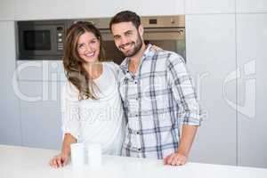 Happy young couple standing by table