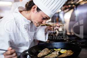 Chef smelling fried fish in the kitchen