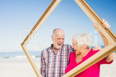 Senior couple holding frame