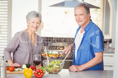 Portrait of happy senior couple preparing food