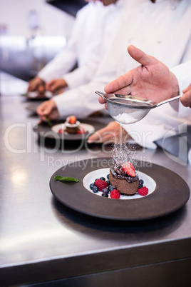 Close-up of chef finishing a dessert plate