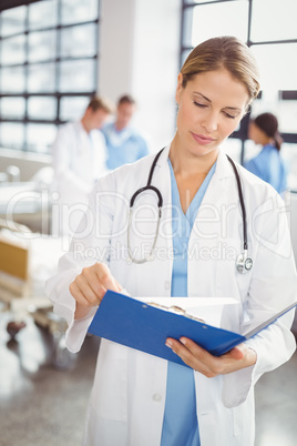 Female doctor looking at medical report
