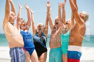 Seniors with hands up at the beach