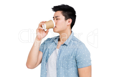 Young man drinking coffee from a disposable cup