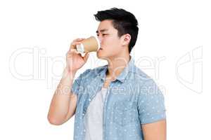 Young man drinking coffee from a disposable cup