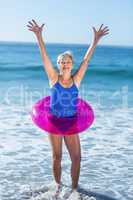 Senior woman with buoy raising arms