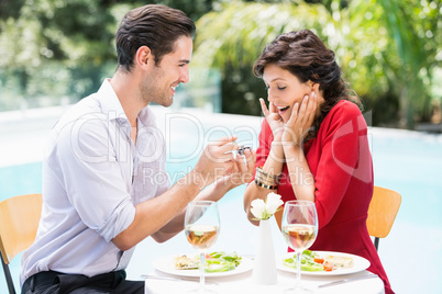 Man giving engagement ring to surprised woman