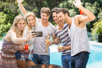 Group of friends taking a selfie near pool