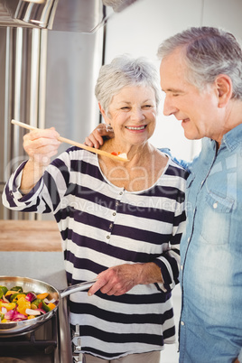 Senior woman feeding food at husband