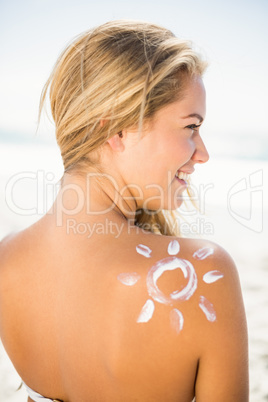 Smiling woman with sunscreen on her skin