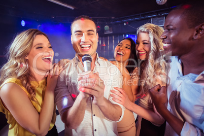 Happy friends singing at the karaoke
