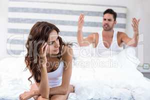 Woman sitting while husband shouting at her