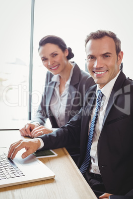 Businessman and businesswoman sitting in conference room