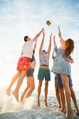 Friends trying to catch volley ball