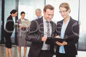 Businessman and businesswoman looking at file