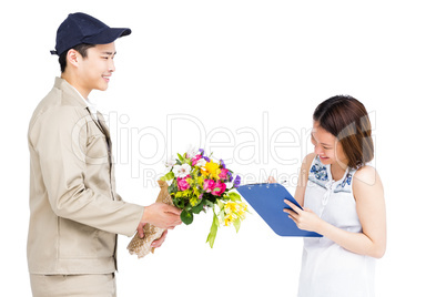 Delivery man taking signature of woman while delivering flowers
