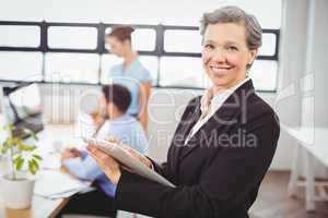 businesswoman using digital tablet with colleagues in background