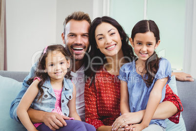 Portrait of cheerful parents sitting with daughters