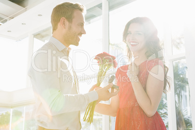 Man offering flowers and engagement ring