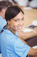 Happy female doctor sitting on conference room
