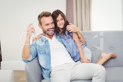 Cheerful daughter and father watching television