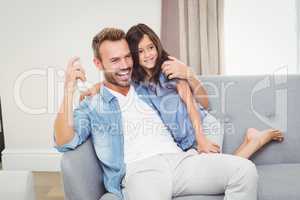 Cheerful daughter and father watching television