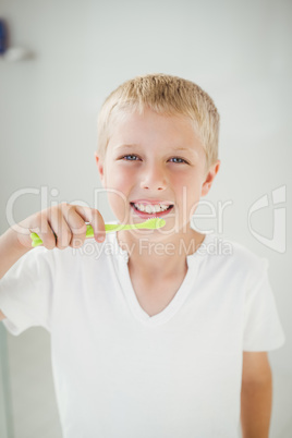 Portrait of boy smiling while brushing teeth