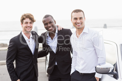 Well dressed men posing next to a limousine