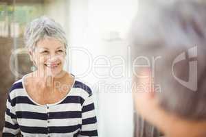 Reflection of happy senior woman on mirror