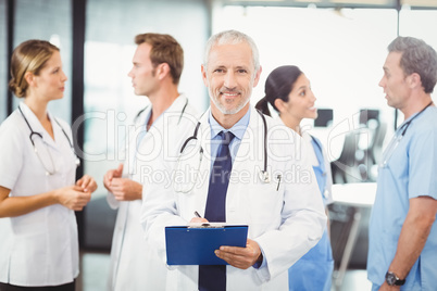 Male doctor writing on clipboard
