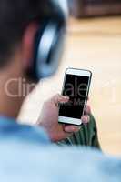 Man listening to music while using mobile phone