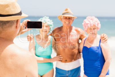 Senior man taking picture of his friends