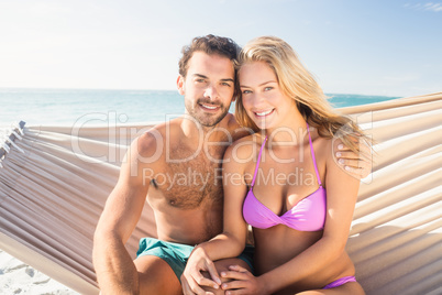 Smiling couple sitting in hammock