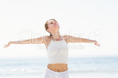 Beautiful woman stretching her arms on the beach