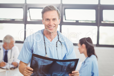 Doctor holding a x-ray report in conference room