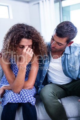 Young couple sitting together and discussing after a fight