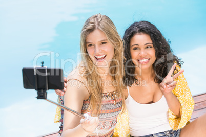 Beautiful women taking a selfie by swimming pool