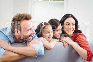 Smiling family leaning on sofa at home