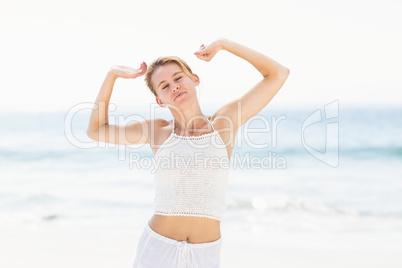 Beautiful woman stretching her arms on the beach