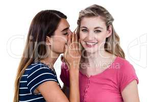 Woman telling secret to friend