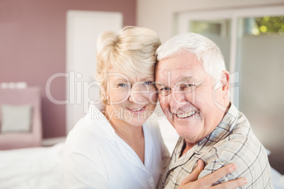 Portrait of happy couple embracing in bedroom