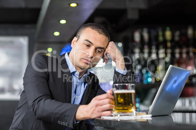 Worried businessman drinking a beer