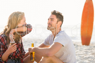 Couple sitting on sand at the beach