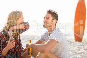 Couple sitting on sand at the beach