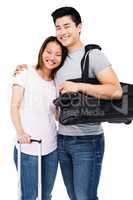 Young couple standing with luggage