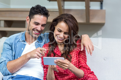 Smiling couple using smartphone